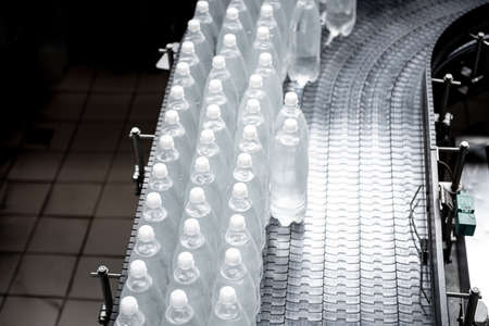 Conveyor belt with bottles for juice or water at a modern beverage plantの写真素材