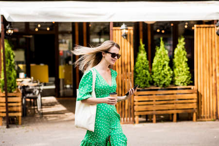 Young beautyful woman with linen eco bag on city background.の写真素材