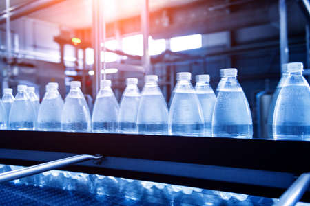 Conveyor belt with bottles of drinking water at a modern beverage plant.の写真素材
