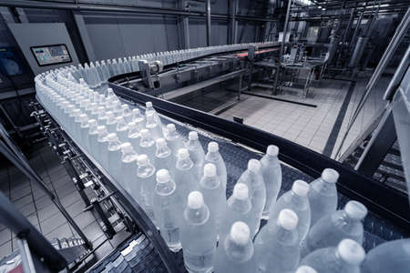 Conveyor belt with bottles of drinking water at a modern beverage plant.の写真素材
