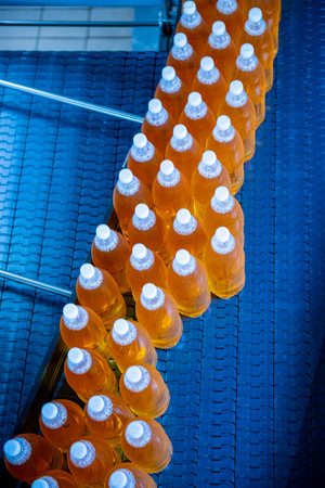 Conveyor belt with bottles for juice or water at a modern beverage plant