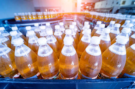 Conveyor belt with bottles for juice or water at a modern beverage plantの写真素材