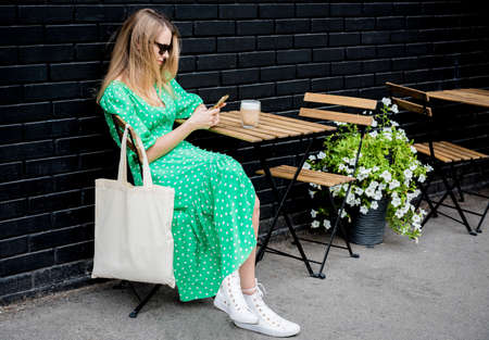 Young beautyful woman with linen eco bag on city background.の写真素材