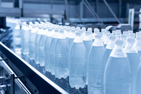 Conveyor belt with bottles of drinking water at a modern beverage plant.の写真素材