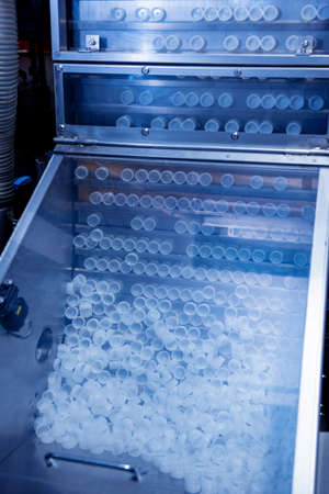 Automatic filling machine pours water into plastic PET bottles at modern beverage plant.の写真素材