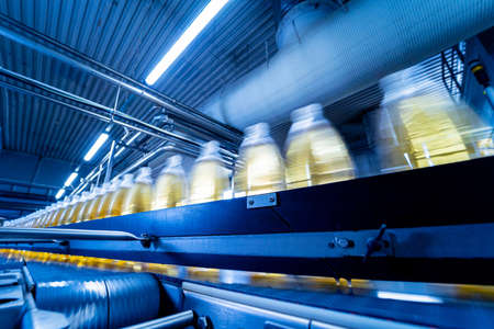 Conveyor belt with bottles for juice or water at a modern beverage plantの写真素材