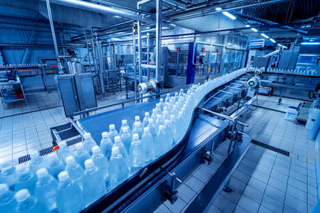 Conveyor belt with bottles of drinking water at a modern beverage plant.の写真素材