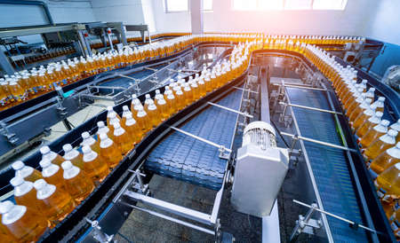 Conveyor belt with bottles for juice or water at a modern beverage plantの写真素材