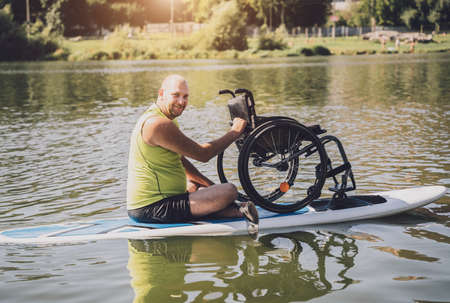 Person with a physical disability ride on sup board with his wheelchairの写真素材