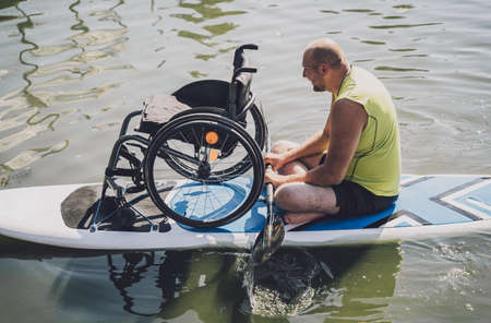 Person with a physical disability ride on sup board with his wheelchairの写真素材