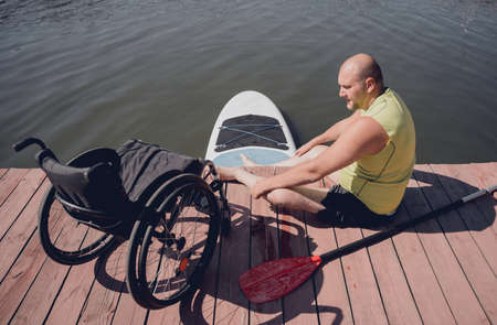 Person with a physical disability in a wheelchair will be ride on sup boardの写真素材
