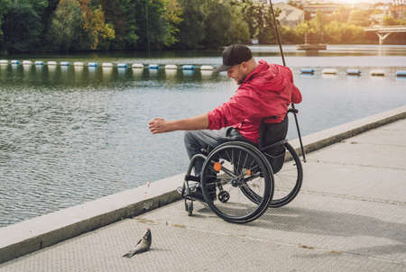 Person with a physical disability in a wheelchair fishing from fishing pier.の写真素材
