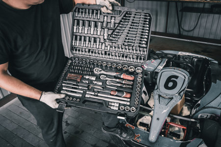 Karting service mechanic holds a set of mechanics tools