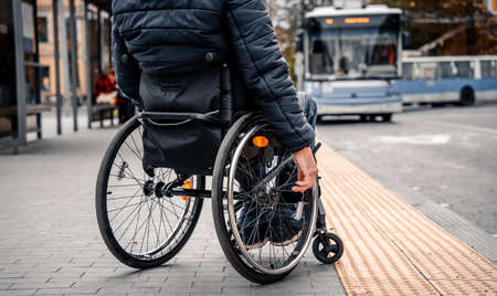Person with a physical disability waiting for city transport with an accessible ramp.の写真素材