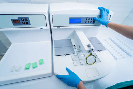 Laboratory assistant works at paraffin wax dispenser tissue embedding machine.の写真素材