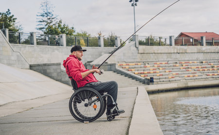 Person with a physical disability in a wheelchair fishing from fishing pier.の写真素材