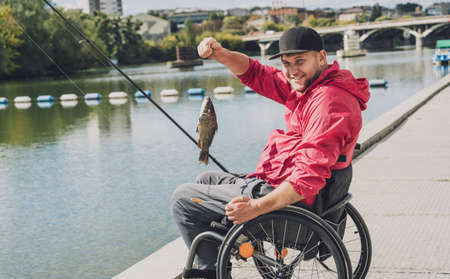 Person with a physical disability in a wheelchair fishing from fishing pier.の写真素材