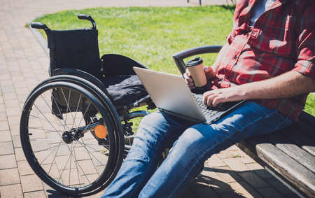 Freelancer with a physical disability in a wheelchair working at the parkの写真素材