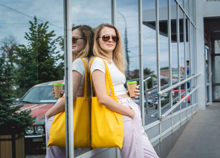 Young beautiful woman with linen eco bag on city background.の写真素材