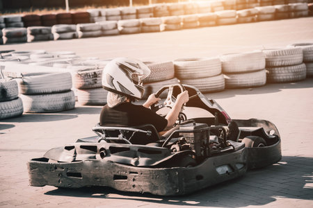 A young man drives a go kart at circuit