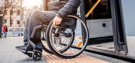 Person with a physical disability exits public transport with an accessible ramp.の写真素材