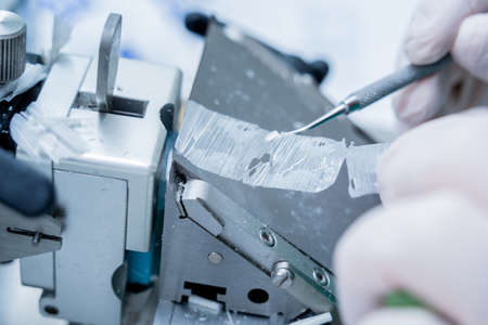 Laboratory assistant works on a rotary microtome section and making microscope slidesの写真素材