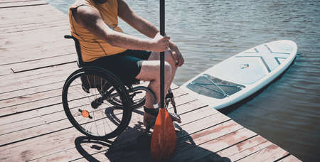 Person with a physical disability who uses wheelchair will be ride on sup boardの写真素材