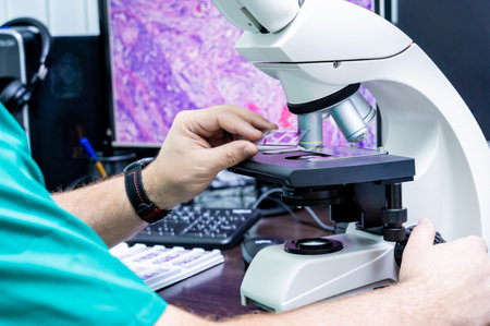 Laboratory assistant works with microscope at the modern laboratory.
