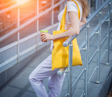 Young beautiful woman with linen eco bag on city background.の写真素材