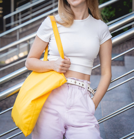 Young beautiful woman with linen eco bag on city background.の写真素材