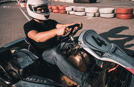A young man drives a go kart at circuit