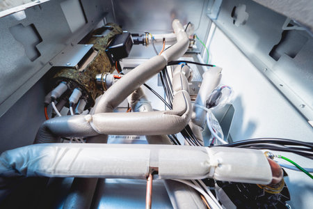 Open air conditioner unit with wires, pipes and electrical equipment