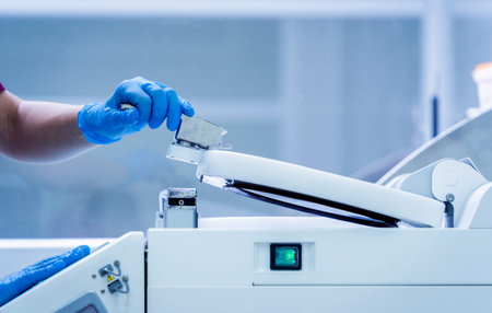 Laboratory assistant works with microwave hybrid tissue processor at the modern laboratory.