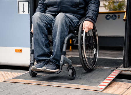 Person with a physical disability exits public transport with an accessible ramp.の写真素材