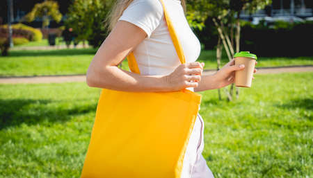 Young beautiful woman with linen eco bag on city background.の写真素材