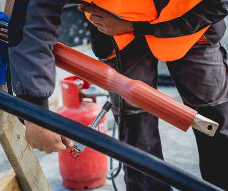 Two electrician builder workers installing high-voltage cableの写真素材