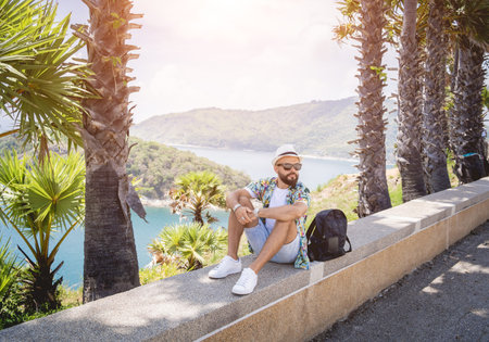 Young traveler man at summer holiday vacation with beautiful palms and seascapes at backgroundの写真素材