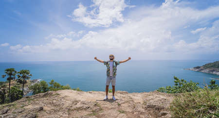 Young traveler man at summer holiday vacation with beautiful mountains and seascapes at backgroundの写真素材