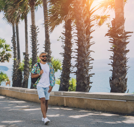 Young traveler man at summer holiday vacation with beautiful palms and seascapes at backgroundの写真素材