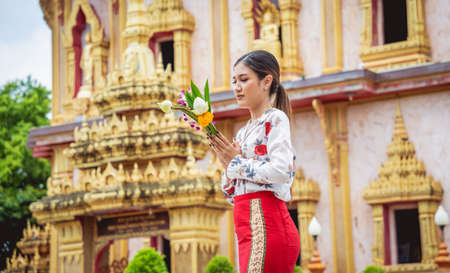 Beautiful Asian girl at big Buddhist temple dressed in traditional costumeの写真素材