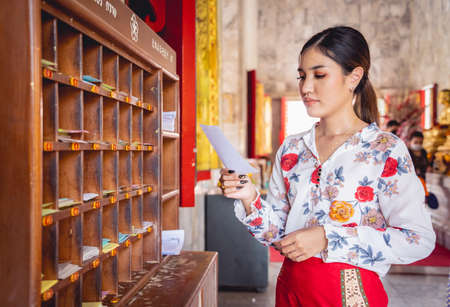 Beautiful Asian girl at big Buddhist temple dressed in traditional costumeの写真素材
