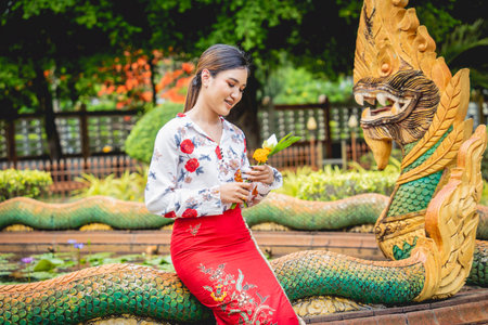 Beautiful Asian girl at big Buddhist temple dressed in traditional costume