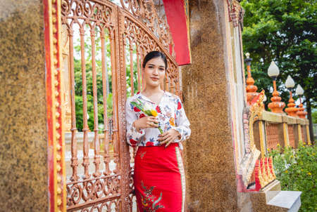 Beautiful Asian girl at big Buddhist temple dressed in traditional costumeの写真素材