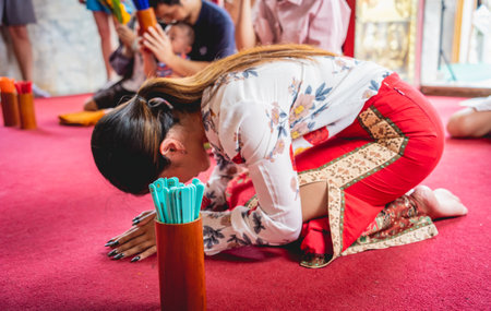 Beautiful Asian girl at big Buddhist temple dressed in traditional costumeの写真素材