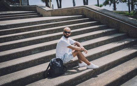 Lonely young handsome man sitting on stairs at the park