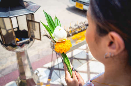 Beautiful Asian girl at big Buddhist temple dressed in traditional costumeの写真素材