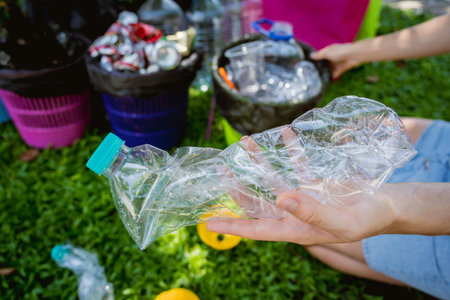 Young beautiful girl sorts garbage into special bins
