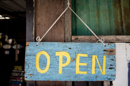 Wooden open sign board in tropical cafe