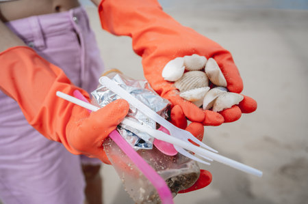 A female ecologist volunteer cleans the beach on the seashore from plastic and other waste