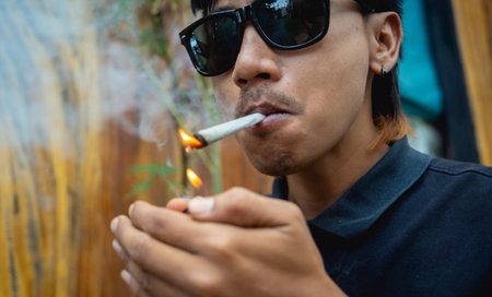 Young man smoking cigarettes with medical marijuanaの写真素材